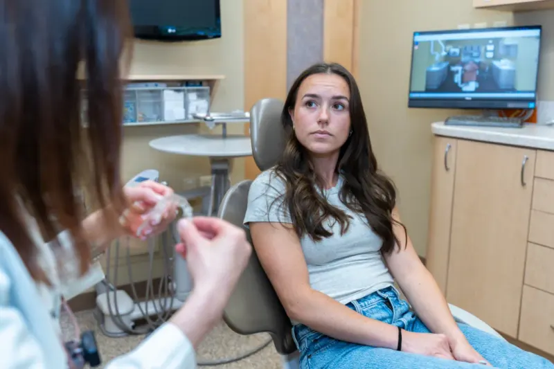 Relaxed patient in the dental chair talking with a hygienist