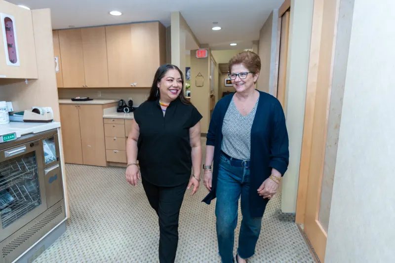 Dentist and patient walking together through the office